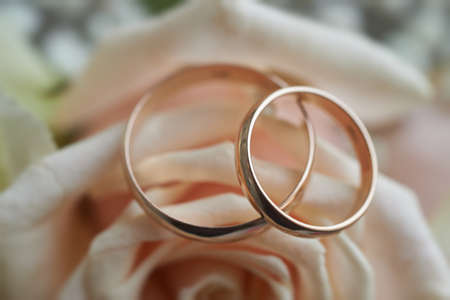 gold rings and a beautiful bridal bouquet of roses on the background. details, wedding traditions. close-up, macroの写真素材