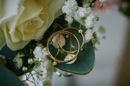 gold rings and a beautiful bridal bouquet of roses on the background. details, wedding traditions....