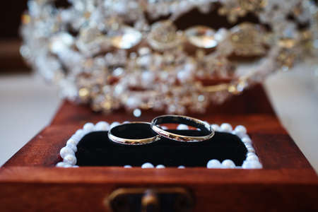 silver wedding rings in a wooden box decorated with pearls. vintage backgroundの写真素材
