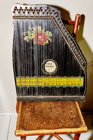 vintage black harp with a floral pattern on an antique chair.
