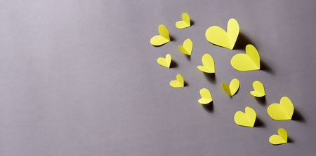 Flying paper hearts on a gray paper background. Horizontal banner, copy space.の写真素材