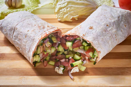 Vegan doner roll with beans in pink pita bread on a white wooden background.Close-up, macroの写真素材