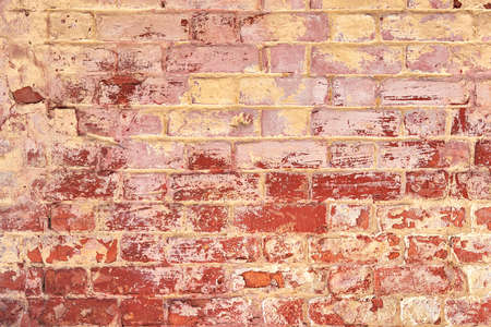 The texture of an old red and yellow brick wall. Close-up, pattern.