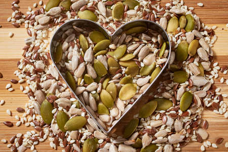 Seeds and grains on a wooden board. Healthy eating. Close-up, macro