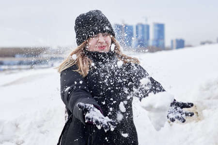 A young girl in black clothes holds a photo lens with an inverted image - her face. Close-up.
