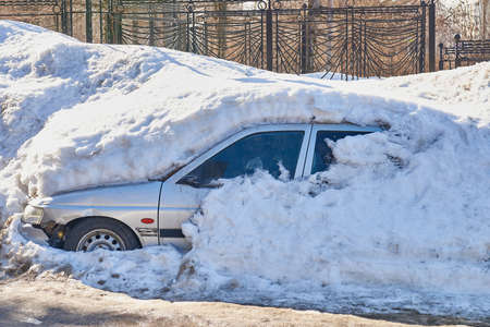 The old broken car is completely covered with snow.の写真素材