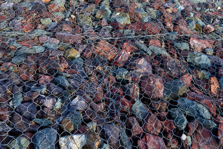 Granite stones under the grate. Pattern, background. Landslide protection.の写真素材