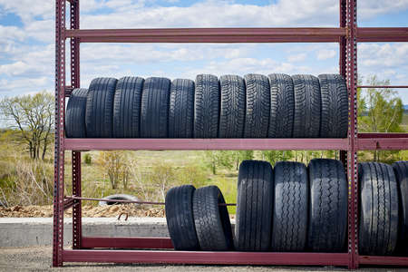 Storage and sale of old car tires. Open-air shop on the road.