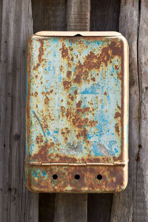 An old rusty mailbox on a wooden fence. Close-upの写真素材