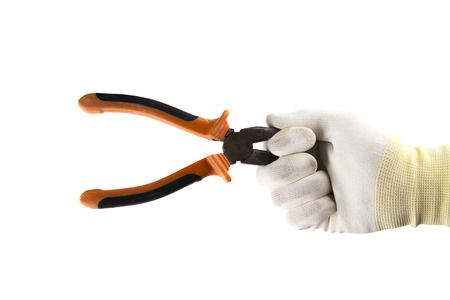 Orange and black flat-nose pliers in the hand in white glove isolated on white backgroundの写真素材