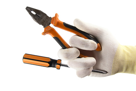 Orange screwdriver and flat-nose pliers in the hand in glove isolated on white backgroundの写真素材