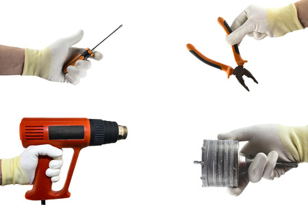 Different construction tools in the hand. Isolated on white backgroundの写真素材