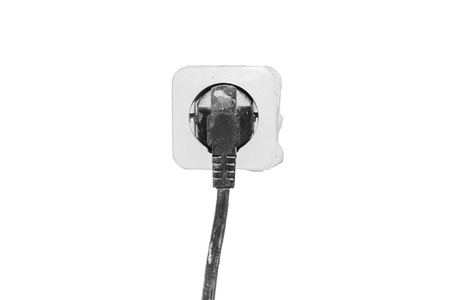 Black electric plug in the white dirty socket isolatd on white backgroundの写真素材