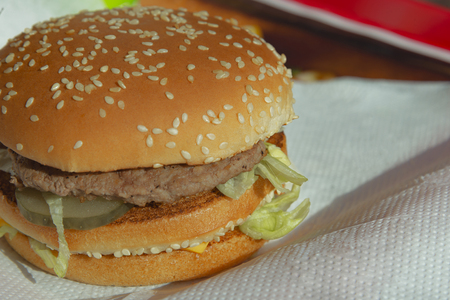 Big juicy burger with cheese on paper towel closeupの写真素材