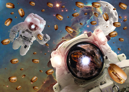 Astronauts in outer space with cheseburgers on the pillar of creation and the Moon on the background.の写真素材