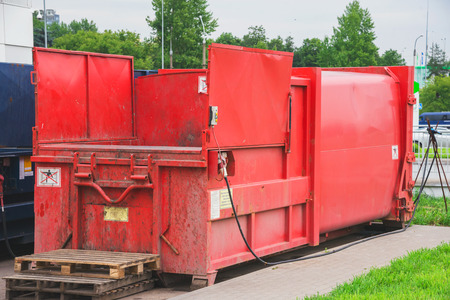 Red garbage press in the street