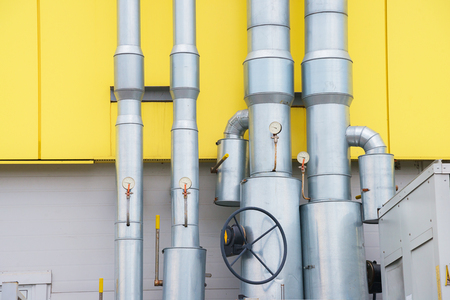 metal pipes with manometers and valves on the yellow and grey wallの写真素材