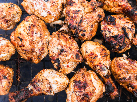 Grilled chicken legs on the grill with smokeの写真素材