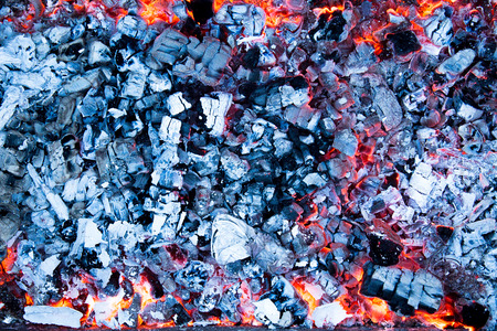 Hot red and black coals with ash in the grill