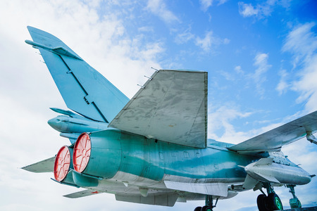 Russian jet combat aircraft tail side with red engine plugs under blue sky