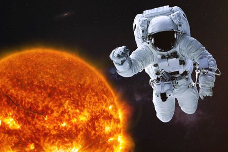 Astronaut in outer  with Sun of solar system. Science fiction wallpaper. Elements of this image were furnished by .の写真素材