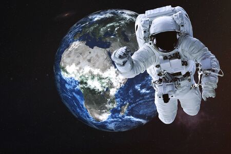 Astronaut near the Earth planet of Solar system. Science fiction. Elements of the image are furnished byの写真素材