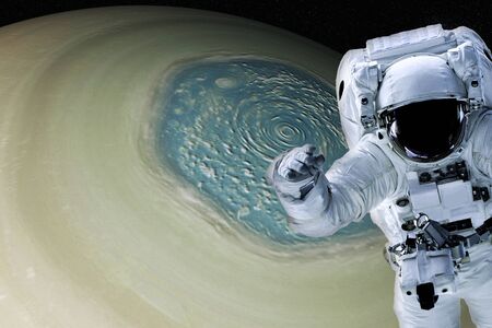 Astronaut close to the saturn planet North side of Solar system. Science fiction. Elements of the image are furnished byの写真素材