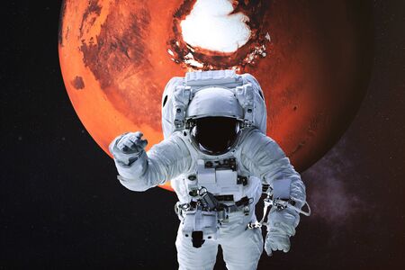 Astronaut in a front of Mars planet of solar system. Science fiction. Elements of the image were furnished byの写真素材