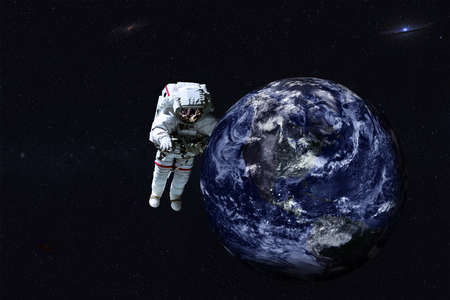 Astronaut and satellite telescope near Earth planet of solar system at night. Science fiction 3D render.の写真素材
