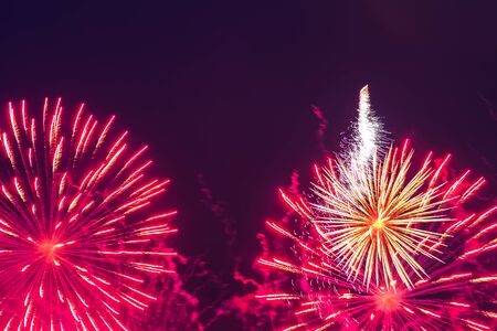 Inexpensive fireworks, over the city, red and pink. Motion blur. Light flares. For any purposeの写真素材