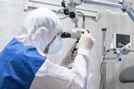 Doctor in protective suit inspecting parient with medical equipment at pandemic period....