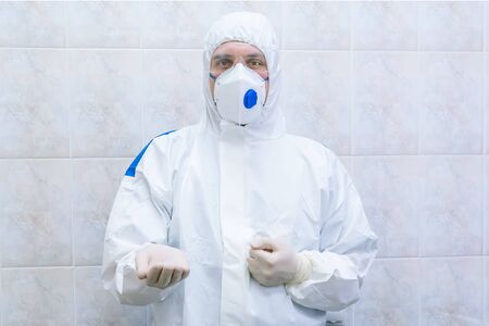 Doctor in protective suit with extended hand at pandemic period. Epidemic disease concept. Selective focus.の写真素材