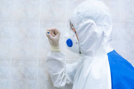 Blue and white pill in doctors hand with gloves closeup. Sickness cure concept, Selective focus.
