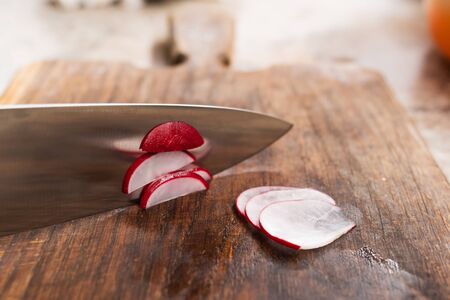 Sliced radish with knife on a wooden Board. Selective focus. High quality photoの写真素材
