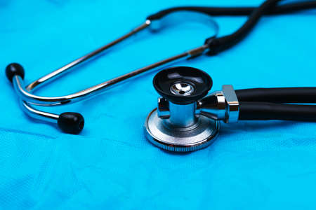 Black Stethoscope and phonendoscope on the blue nonwoven fabric. Selective focus. Medical concept.の写真素材