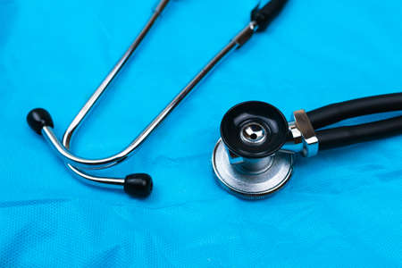 Black Stethoscope and phonendoscope on the blue nonwoven fabric. Selective focus. Medical concept.の写真素材