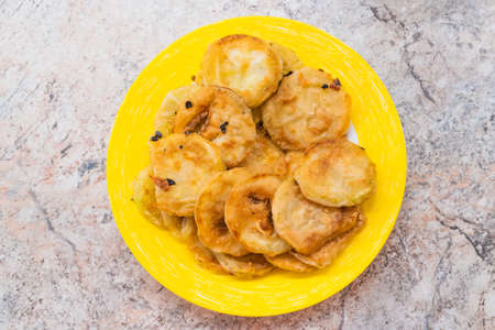 Homemade breaded zucchini rings on yellow plate. High quality photoの写真素材