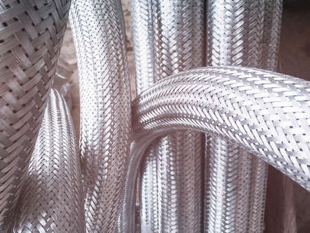 Long metal flexible compensator pipes metal texture closeup with lens flare. Selective focus. White metal industrial construction.の写真素材
