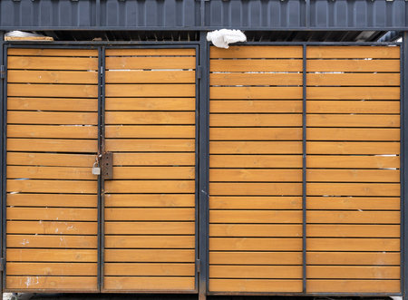 Metal and wooden doors of garbage storage room close upの写真素材