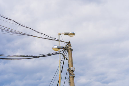 High Voltage Field with Surveillance Camera and illumination lamp Against Blue Skyの写真素材