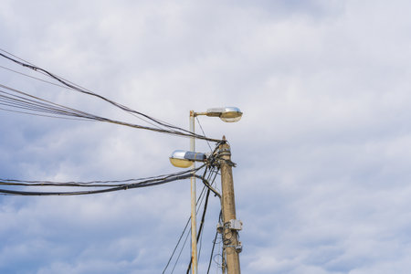 High Voltage Field with Surveillance Camera and Street Light Against Blue Skyの写真素材
