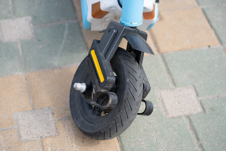 Close-up of Broken Electric Scooter Front Wheel on Gray Asphalt Backgroundの写真素材