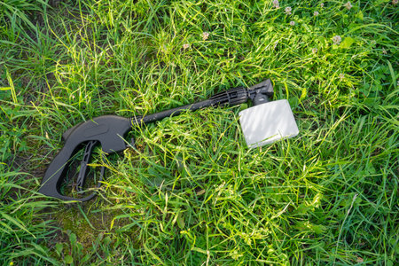 Handle and sprayer of a high-pressure washer with foam generator on green grassの写真素材