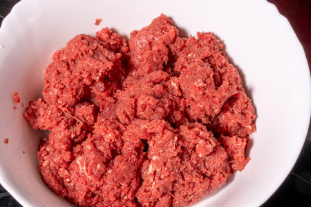 minced meat in a white bowl on a black background closeupの写真素材