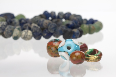 Ancient and new glass beads on white backgroundの写真素材