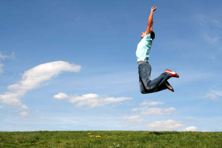 Man jumping against blue skyの写真素材