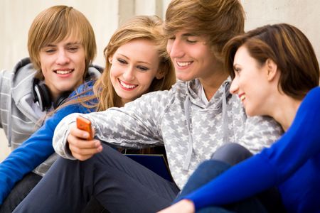 Friends looking on cellphoneの写真素材
