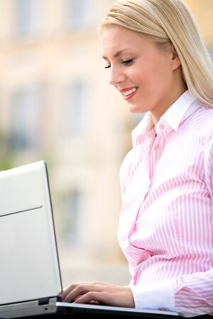 Woman using laptop outdoorsの写真素材
