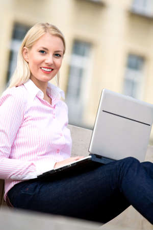 Woman using laptop outdoorsの写真素材