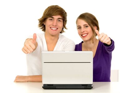 Couple using laptop showing thumbs upの写真素材